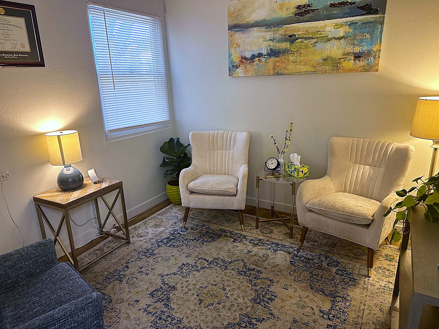 The therapy room: two comfortable armchairs, soft lamplight, and calming artwork